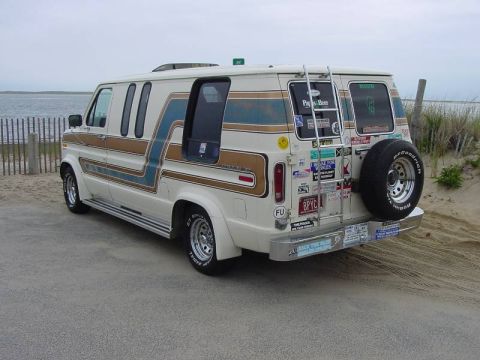 1981 Ford E150 - This van is parked near a beach with a wooden fence and sand dunes.