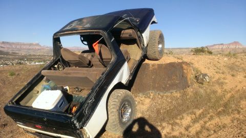1994 Ford Bronco - This vehicle is positioned precariously on a dirt embankment under a clear blue sky.