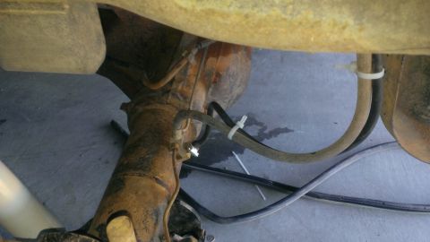 1994 Ford Bronco - Underside view of a vehicle's rear axle and associated lines.