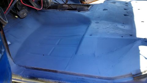 1979 Ford Bronco - The interior floor of a vehicle has been painted blue, revealing the pedals and some wiring.