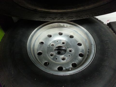 1994 Ford Bronco - A close-up view of a tire and wheel assembly, with text visible on the tire's sidewall.