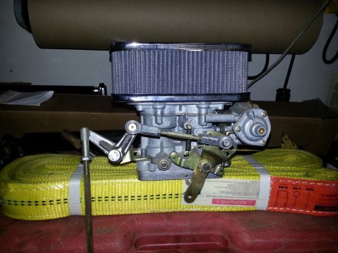 1994 Ford Bronco - Carburetor assembly with air filter, resting on yellow tie-down straps.