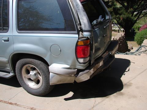 1973 Ford Ranchero - This light blue SUV has significant rear-end damage, including a broken taillight and a dented bumper.