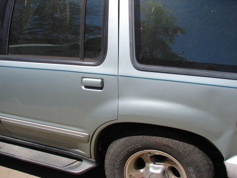 1973 Ford Ranchero - Close-up of a silver SUV's side, showing the rear door and wheel with tire details.