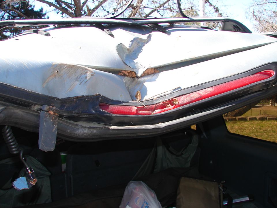 1973 Ford Ranchero trunk lid severely damaged, showing exposed wood and red taillight assembly
