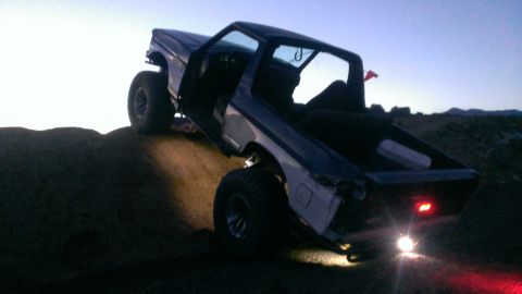 1994 Ford Bronco - This SUV is angled on a dirt mound with its doors open as the sky darkens.