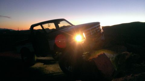 1994 Ford Bronco - A vintage Ford F-Series truck is silhouetted against a sunset sky.