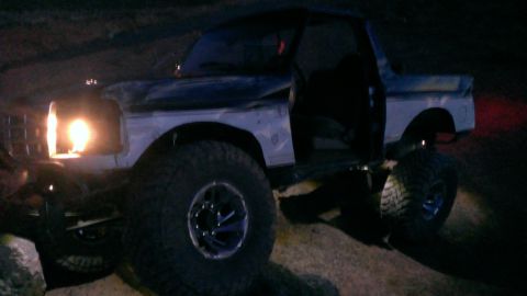 1994 Ford Bronco - This modified Ford Bronco is shown off-roading at night with its headlights on.