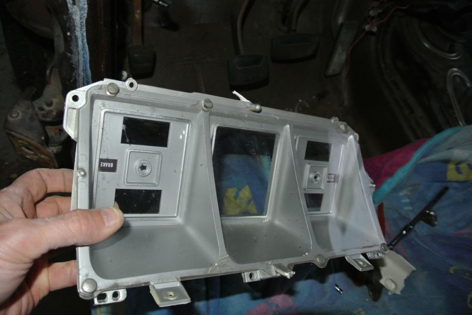 Silver dashboard instrument cluster with multiple gauge openings and a "BRAKE" label