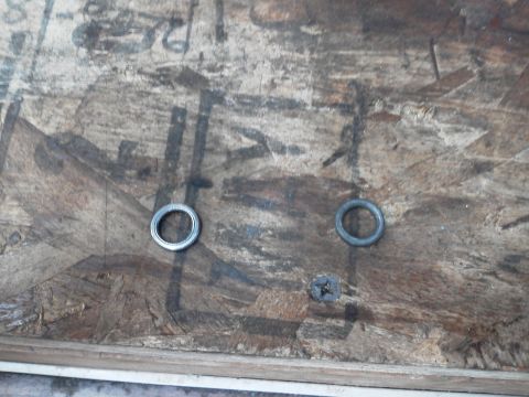 1988 Ford Bronco - Two washers and a screw are placed on a textured wooden surface.