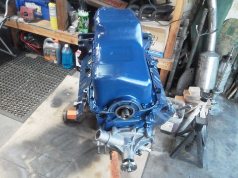 1988 Ford Bronco - A blue engine block with its water pump assembly is displayed, likely awaiting installation or rebuild.
