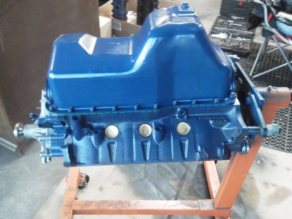 Blue engine block on an orange engine stand. Tools are visible in the background