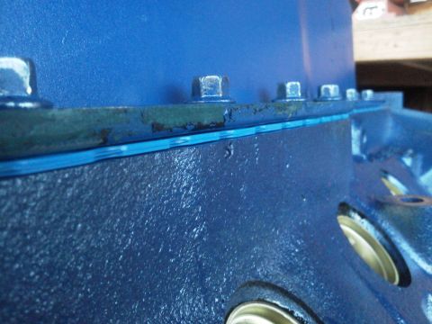 1988 Ford Bronco - Close-up of an engine block showing a teal gasket and hex bolts.