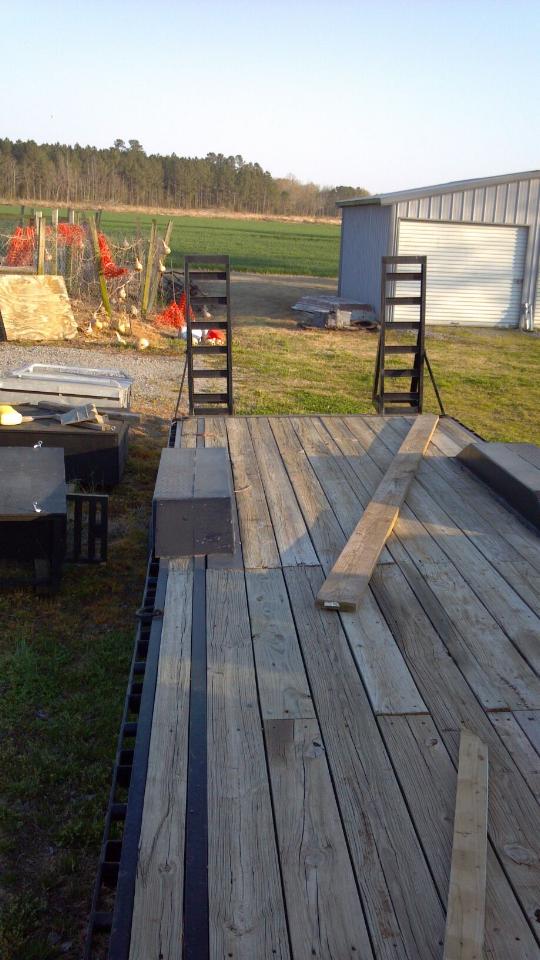 Wooden trailer deck with metal ramps, viewed from the front