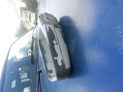 1994 Ford Bronco - Door handle showing primer beneath the blue paint, indicating preparation for a new finish.