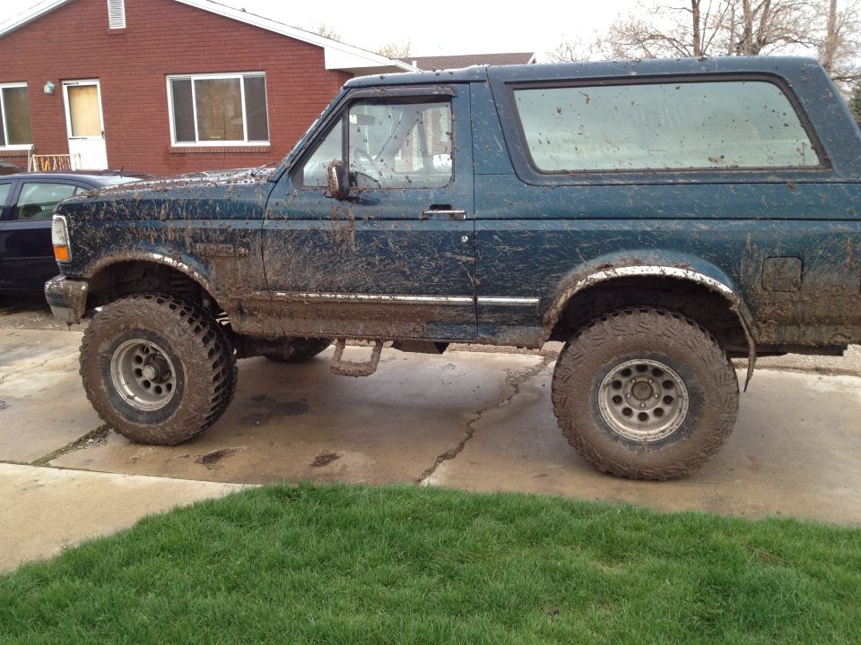 Mud-covered 1994 Ford Bronco parked on a driveway