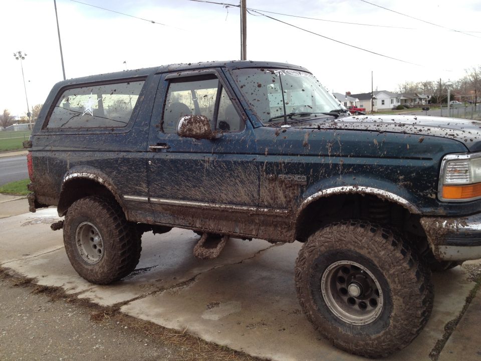 Mud-covered 1994 Ford Bronco parked on a concrete pad