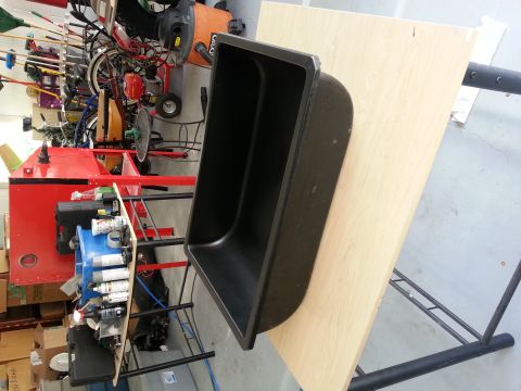 1994 Ford Bronco - A black plastic tub is mounted on a wooden board, with various tools and equipment visible behind it.