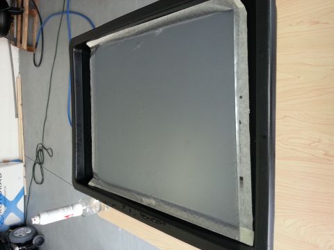 1994 Ford Bronco - A close-up view of a vehicle window frame, with the glass pane covered in protective plastic sheeting.