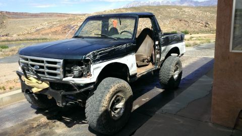 1994 Ford Bronco - This 1994 Ford Bronco shows significant front-end damage and appears to be modified for off-road use.