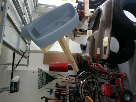 1994 Ford Bronco - A car door panel and tire are stored in a garage with various tools and equipment.