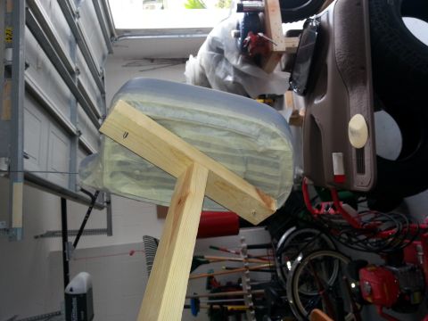 1994 Ford Bronco - A vehicle part, likely a fender or body panel, is taped and mounted on a wooden stand in a garage, possibly for hydrographic treatment.