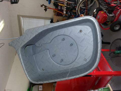 1994 Ford Bronco - A gray plastic tub is shown in a garage setting, with various items in the background.