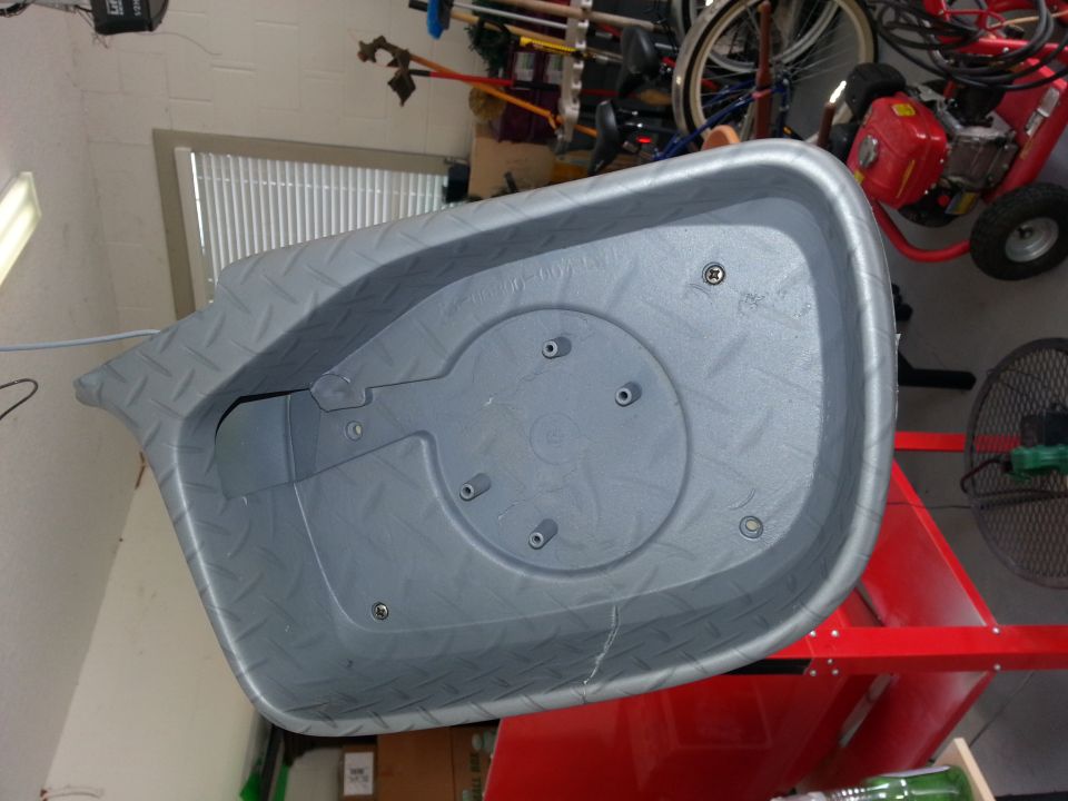 Gray plastic tub with diamond plate texture on the rim, inside a garage