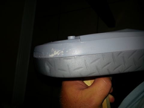 1994 Ford Bronco - A hand holds a gray plastic object with a textured edge, showing some wear.