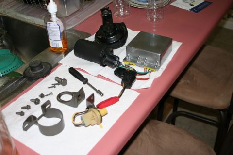 1980 Ford Mustang - Various automotive ignition system components and tools are arranged on a pink table surface.
