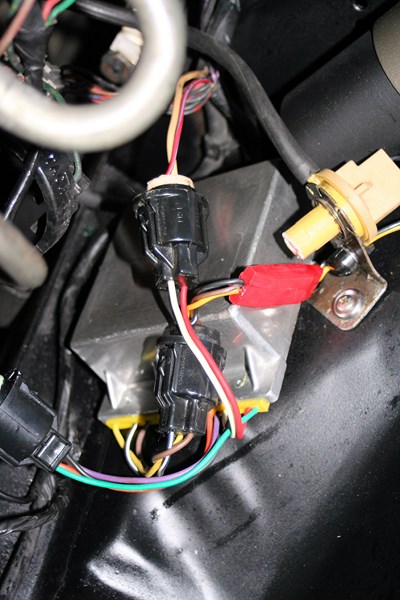 1980 Ford Mustang - A close-up view of a vehicle's wiring harness and connectors, with visible electrical tape and a metal box.