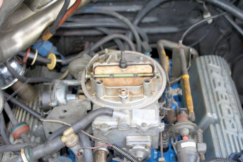 1980 Ford Mustang - Engine bay detail showing a carburetor and associated fuel lines and electrical connections.