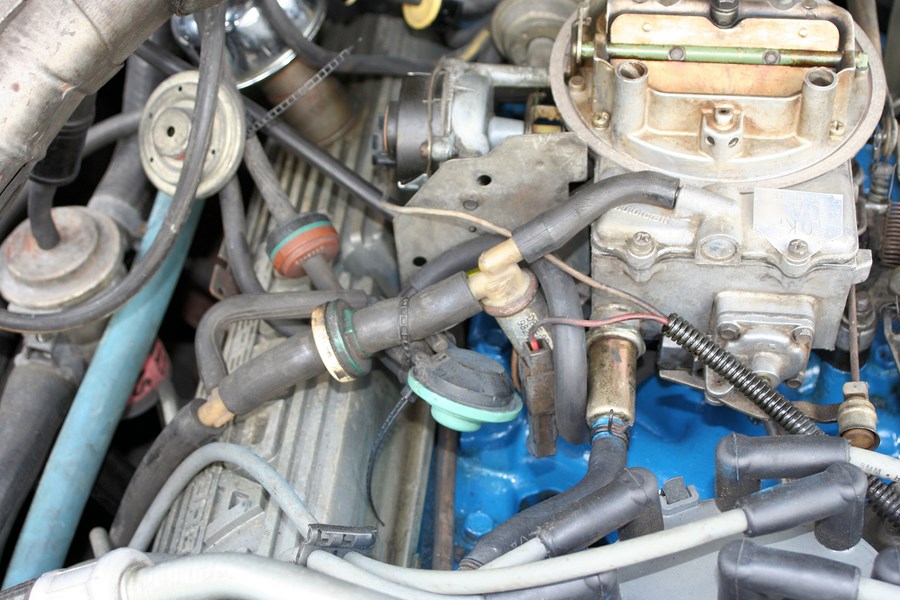 Engine bay with carburetor, distributor, and spark plug wires visible