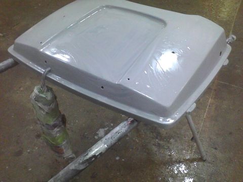 2003 Ford Crown Victoria - A gray hood part is shown on a stand, likely in a workshop or paint booth.