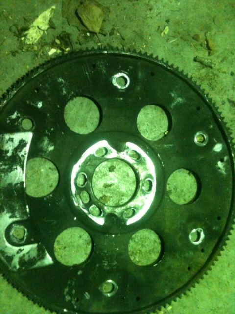 1986 Chevrolet Blazer - A car part, a flywheel, is shown lying on the ground with debris.