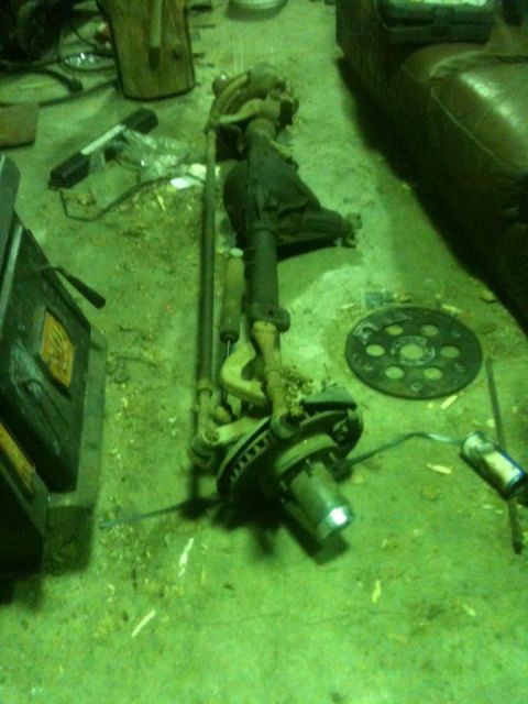 1986 Chevrolet Blazer - A disassembled front axle assembly lies on a workshop floor, suggesting repair or modification.