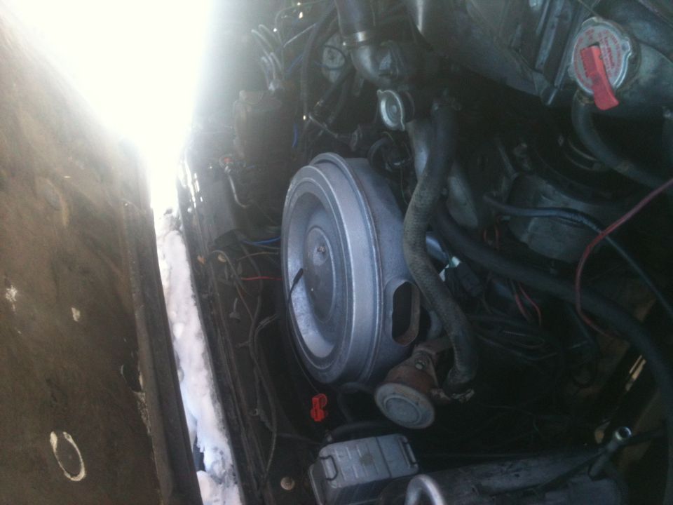 Engine bay with air cleaner and hoses visible