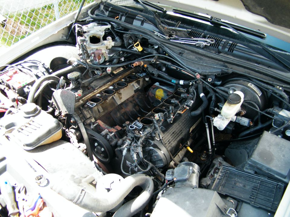 Engine bay with parts removed, showing the V8 engine
