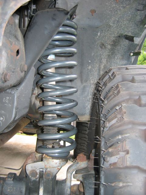 1992 Ford Bronco - Close-up view of a vehicle's front suspension coil spring and tire, with visible text from Supermotors.net.