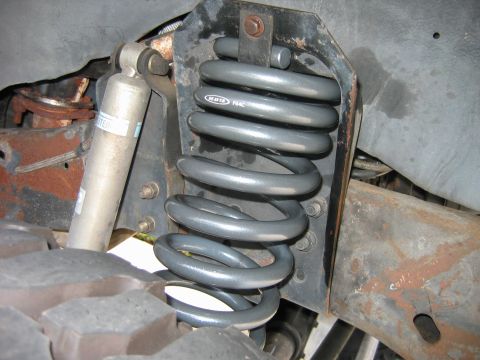 1992 Ford Bronco - The image shows a close-up view of a vehicle's front suspension components, including a coil spring and shock absorber.