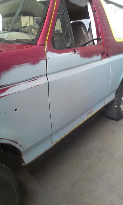 1994 Ford Bronco - This SUV is undergoing bodywork, with primer and red paint visible on its side.