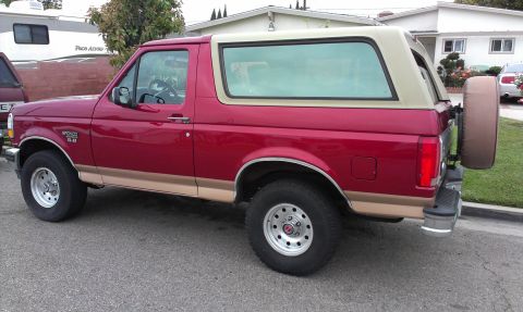 1994 Ford Bronco - This 1994 Ford Bronco is parked on a residential street, showing its side profile and rear-mounted spare tire.