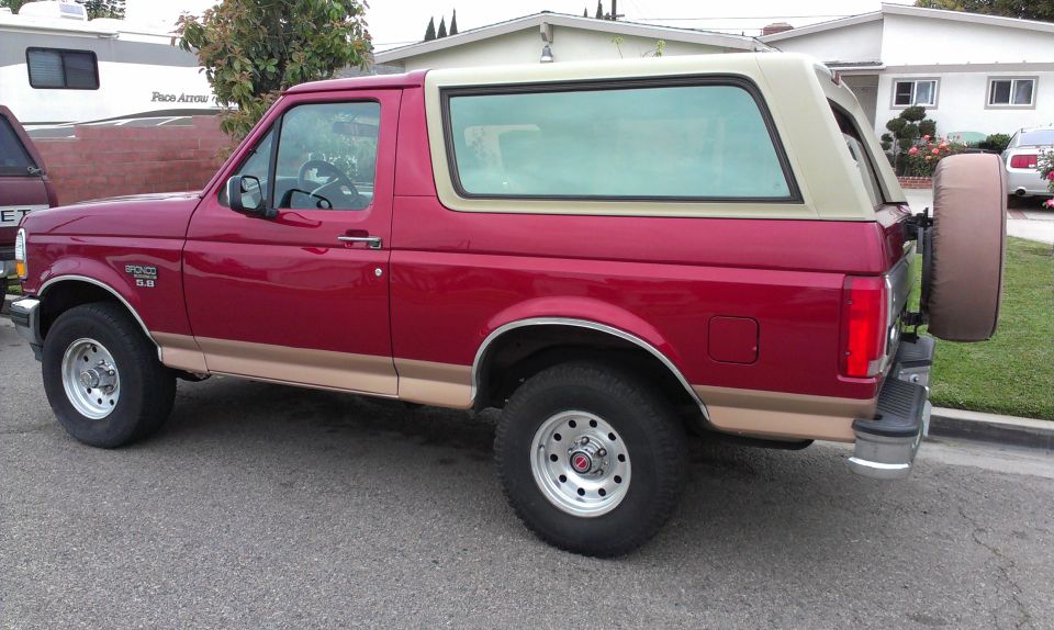 Red 1994 Ford Bronco with tan two-tone paint and a spare tire on the back