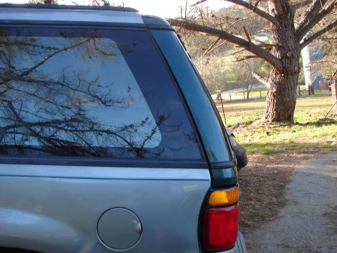 1973 Ford Ranchero - The rear section of an SUV is visible, with a large tree and rural landscape in the background.