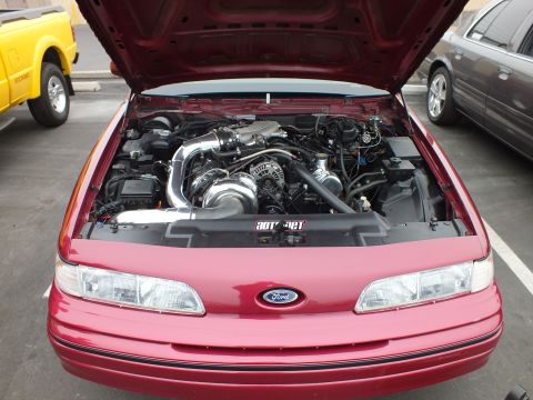 2003 Ford Crown Victoria - Engine bay of a red Ford Crown Victoria showing a ProCharger supercharger, polished intake tube and Ford-badged front panel.
