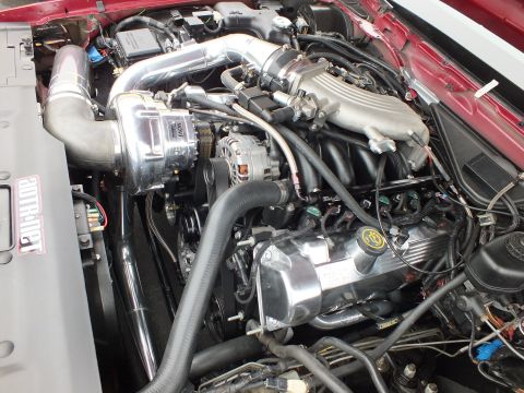 2003 Ford Crown Victoria - Engine bay of a red car fitted with a centrifugal supercharger, polished intake tubes and alternator