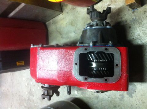 1989 Ford Bronco - A red transfer case assembly, likely for an older 4x4 vehicle, is shown with its internal gears exposed.