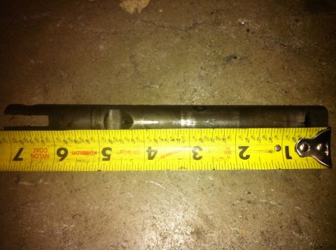 1989 Ford Bronco - A metal shaft is measured with a yellow tape measure, indicating its length.