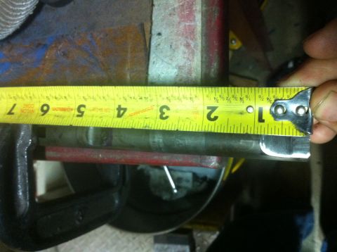 1989 Ford Bronco - A tape measure is used to determine the diameter of a metal rod clamped in a vise.
