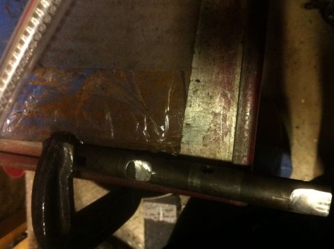 1989 Ford Bronco - A metal shaft, possibly a driveshaft component, is secured in a vise for work.